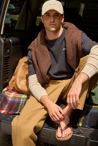 Man sitting in the back of a vehicle wearing layered fall styles.