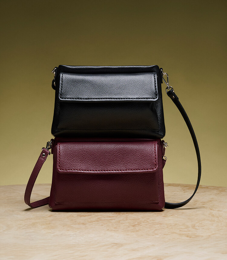 Two leather bags stacked on a table.
