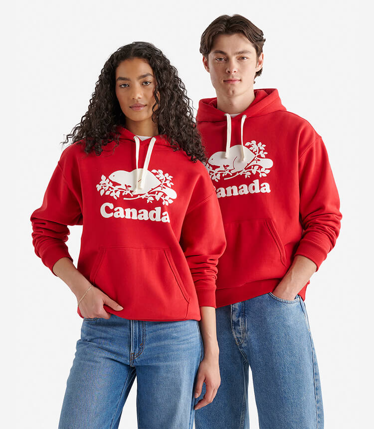 Deux mannequins portant des chandails à capuchon rouges Canada et des jeans bleus.